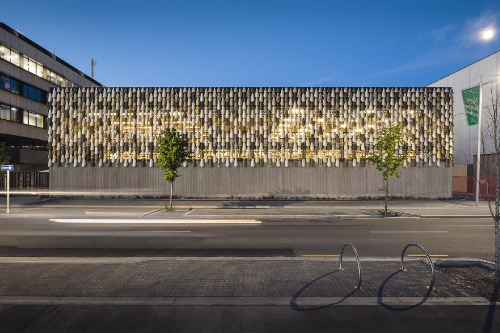 Exterior wall installation of laser-cut panels with golden illumination crafted by Laser 3D for architectural design.