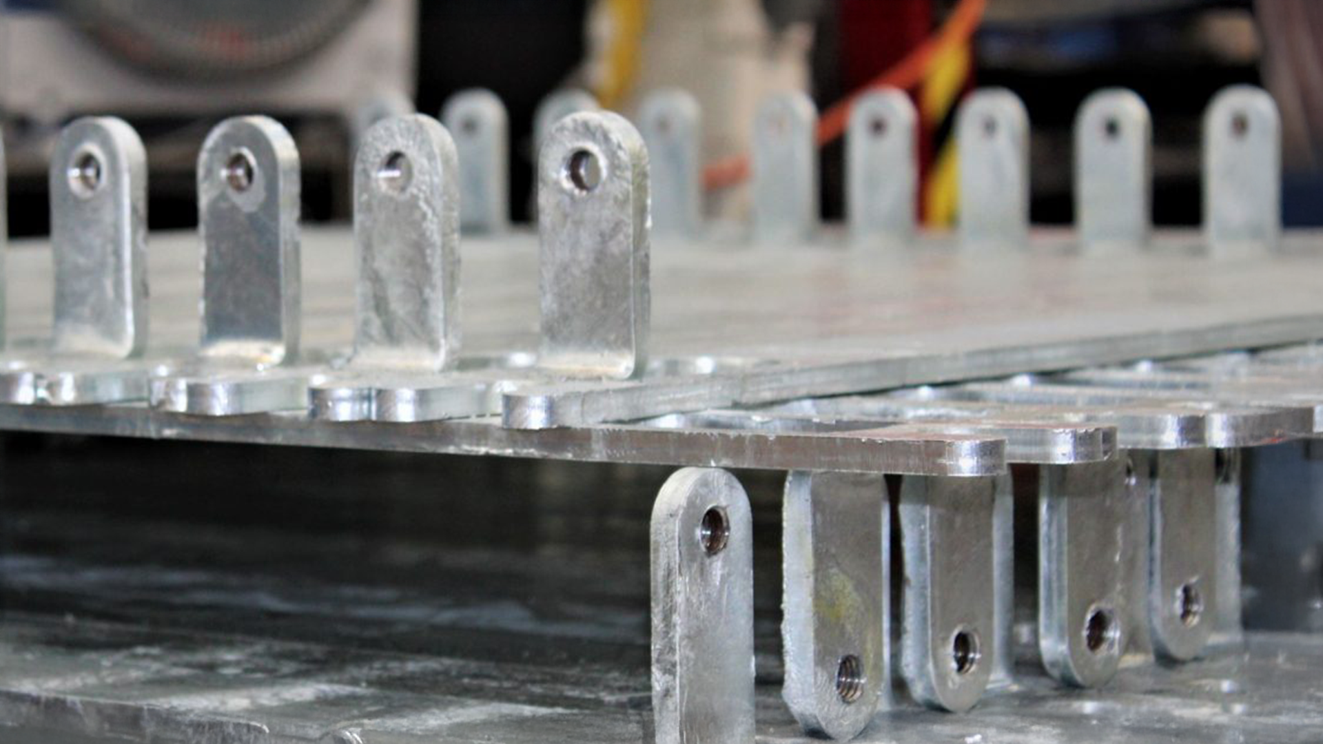 stacked galvanised steel brackets with precision-cut holes showcasing Laser 3D’s laser cutting accuracy